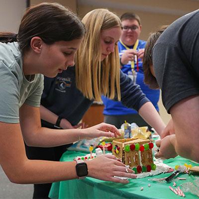 students work on a gingerbread house